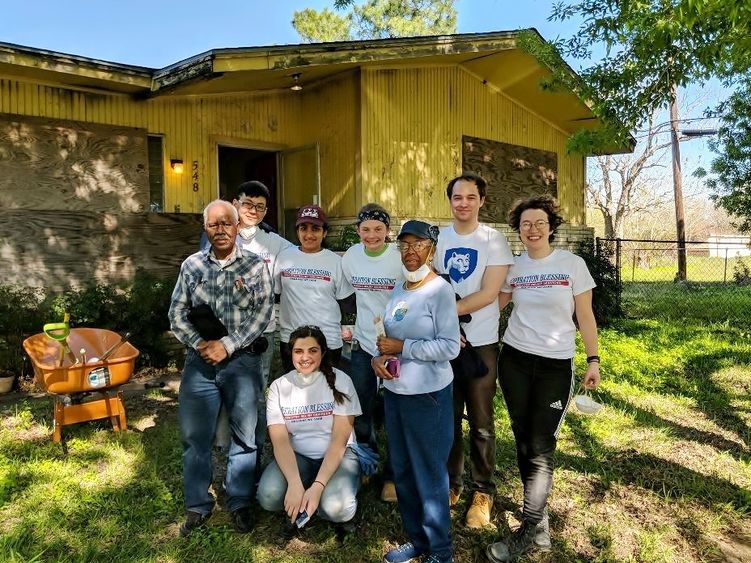 A group of Penn State Behrend students stand with the owners of a Houston home damaged by Hurricane Harvey.