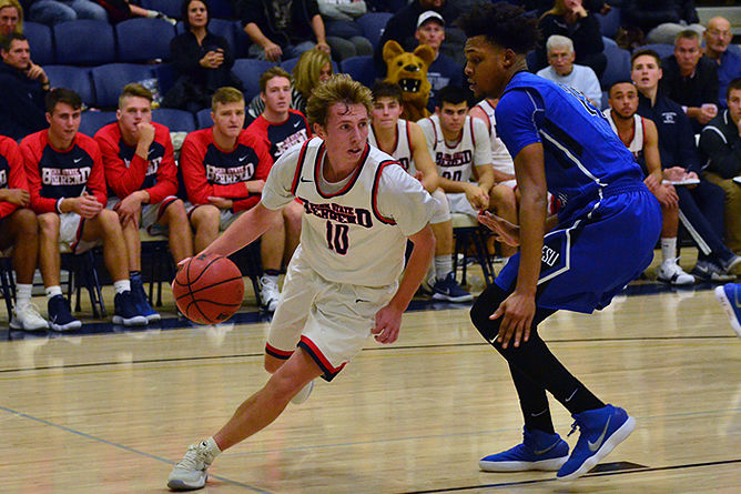 Penn State Behrend basketball player Andy Niland dribbles the ball.