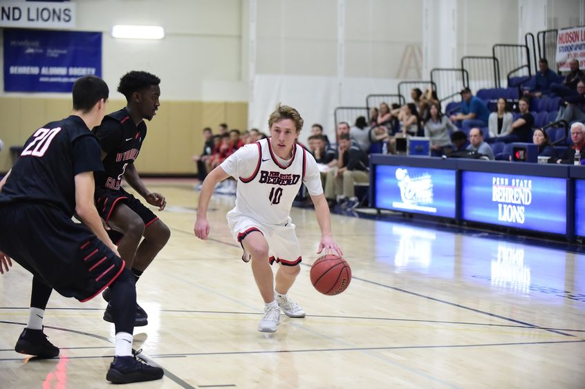 Penn State Behrend basketball player Andy Niland dribbles toward the net.