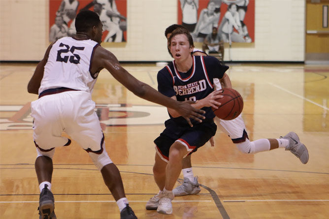 Penn State Behrend basketball player Andy Niland dribbles toward the hoop.