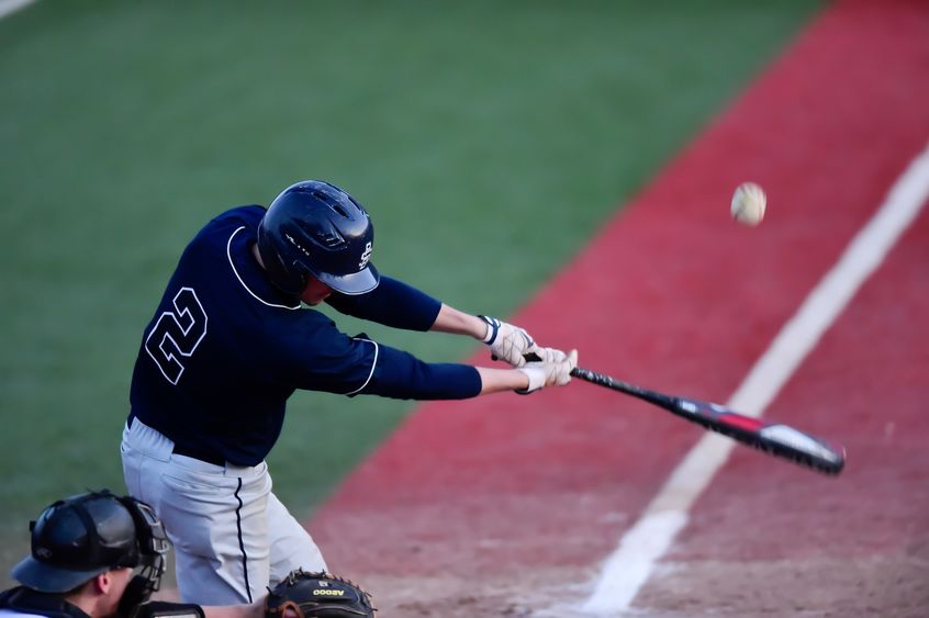 A Penn State Behrend baseball player hits the ball.