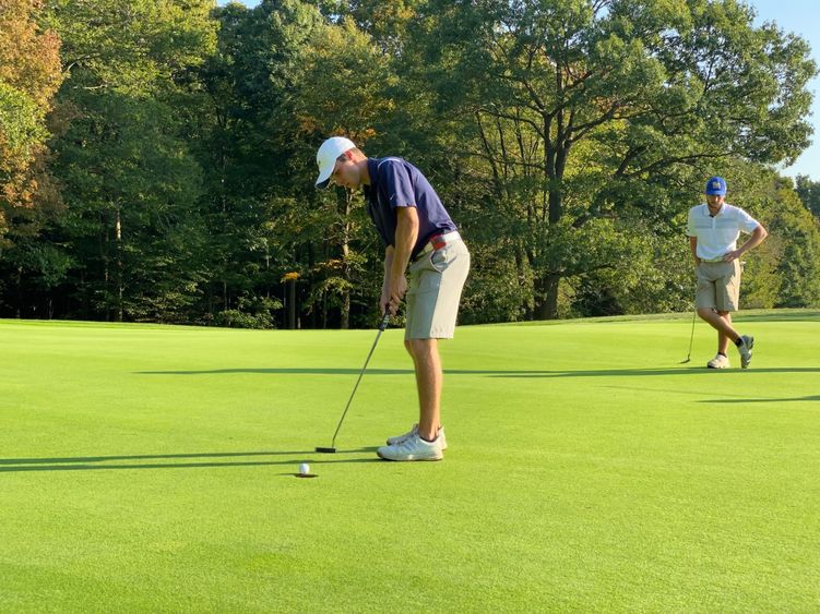 A Penn State Behrend golfer attempts a putt.