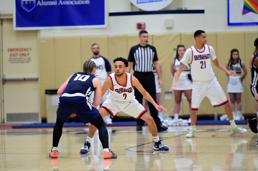 A Penn State Behrend basketball player defends against an opponent's advance.