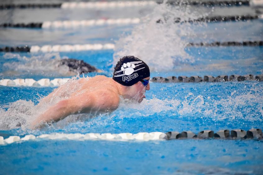 A Penn State Behrend male swimmer competes in a race.