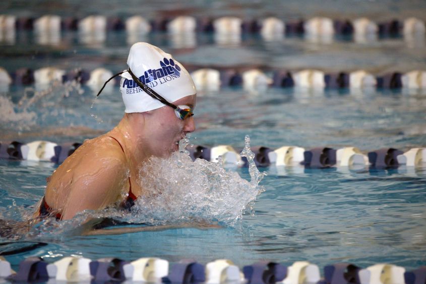 A Penn State Behrend swimmer competes in a race.