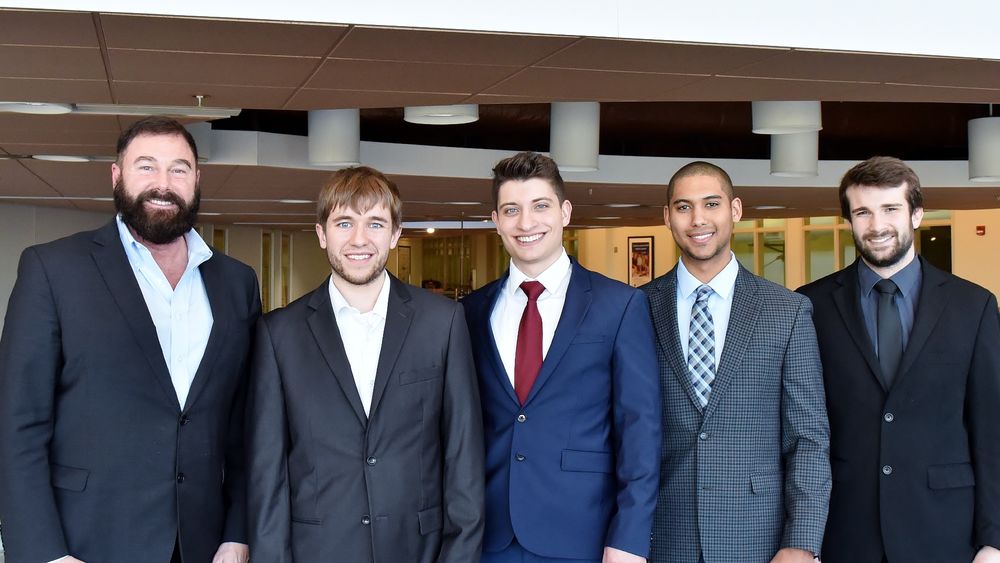 Four students pose with Greg Filbeck, director of the Black School of Business at Penn State Behrend