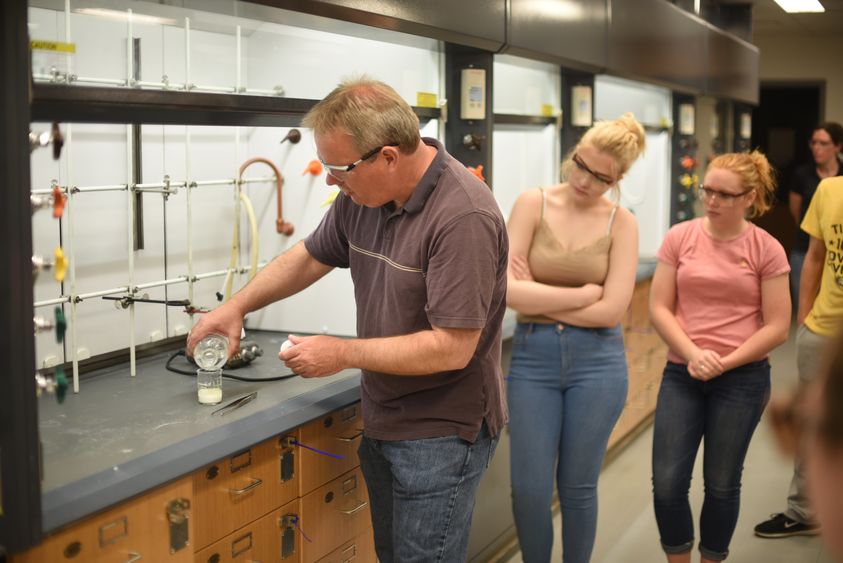 Jerry Magraw, a senior technician, instructs McDowell High School students on creating a compound containing an ester during a chemistry outreach event held Wednesday, May 17, at Penn State Behrend.