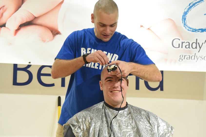 A Penn State Behrnd baseball player shaves a teammates head during a fundraising event.
