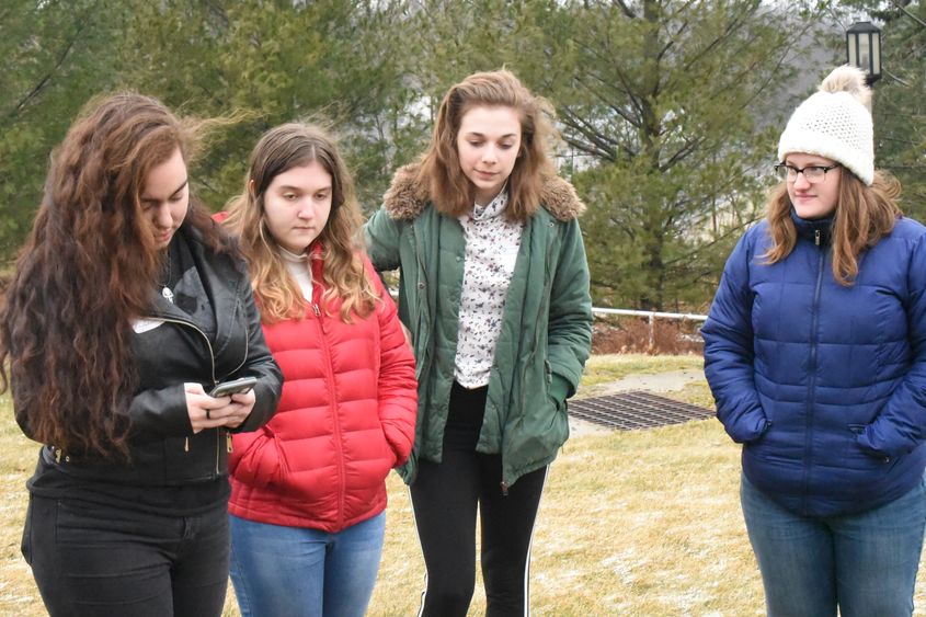 Tori Schwartz, left, collects a GPS point while Claire Dodds and classmates look on. 