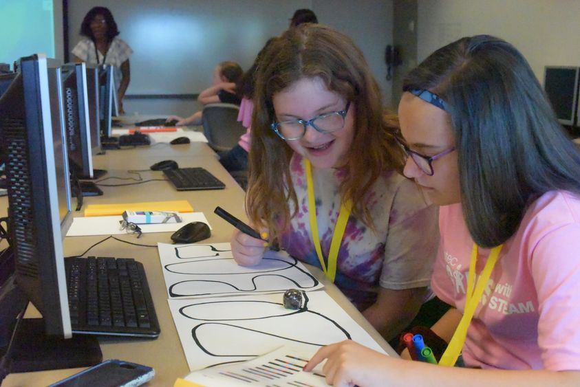 Emma Stafford, left, and Kendra Kope, both students in the General McLane School District, program an Ozobot during the Wabtec Girls With Steam program.