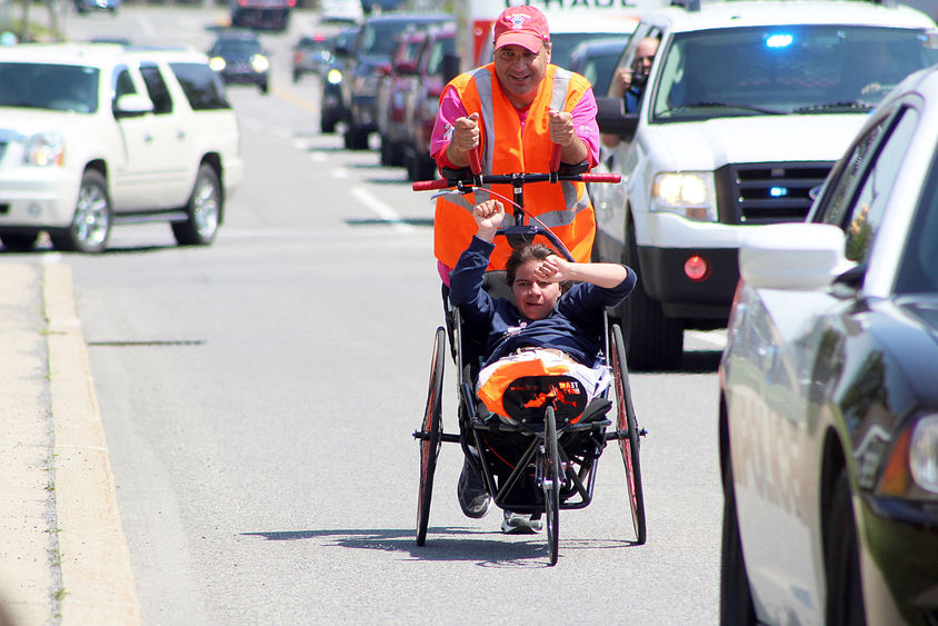 Dan Perritano pushes his daughter Emma in a wheelchair on a charity walk.