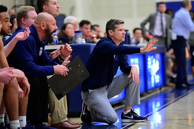 Penn State Behrend men's basketball coach Dave Niland gives instructions from the side of the court.