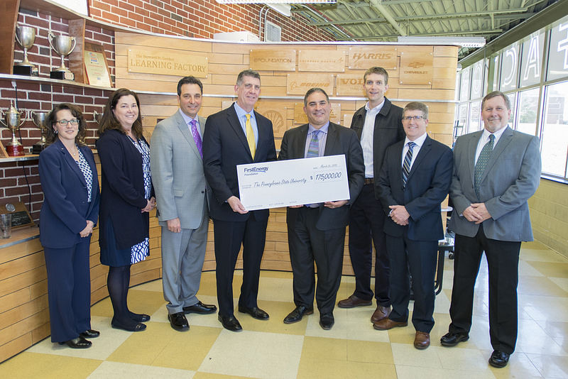FirstEnergy and Penn State representatives holding a large check