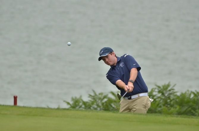 A Penn State Behrend golfer chips the ball onto the green.