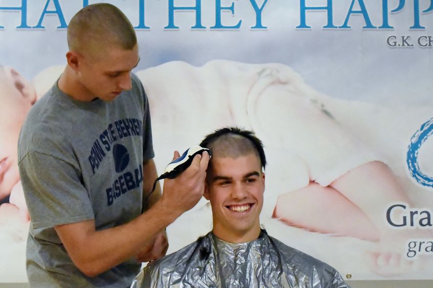 A Penn State Behrend student has his head shaved during a charity event.