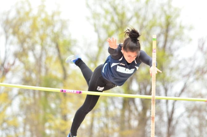 A Penn State Behrend student-athlete completes a pole vault jump.