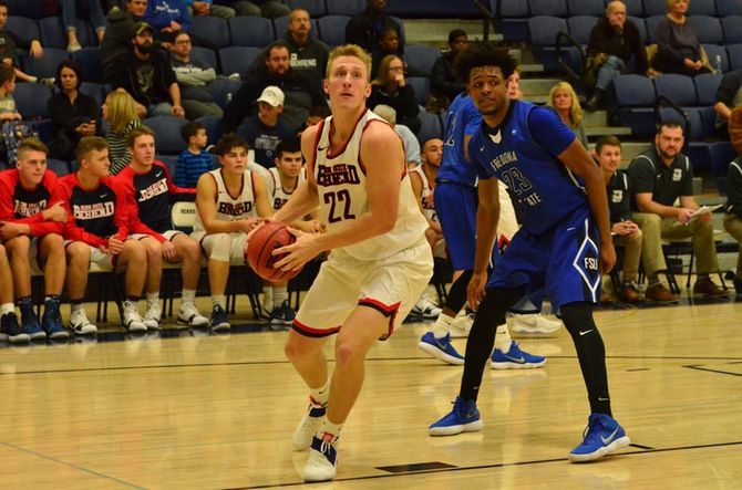 Penn State Behrend basketball player Justin Gorny dribbles the ball