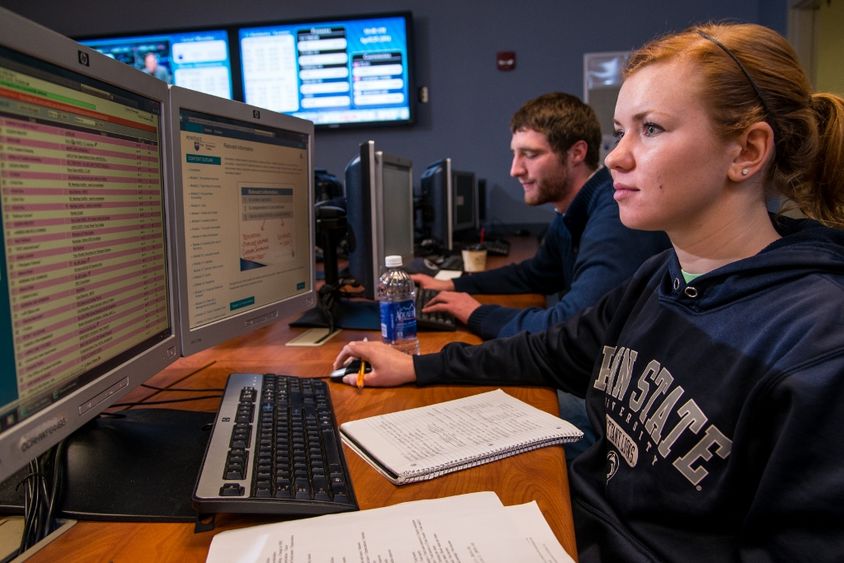 Two students work on computers in the financial trading lab at Penn State Behrend.