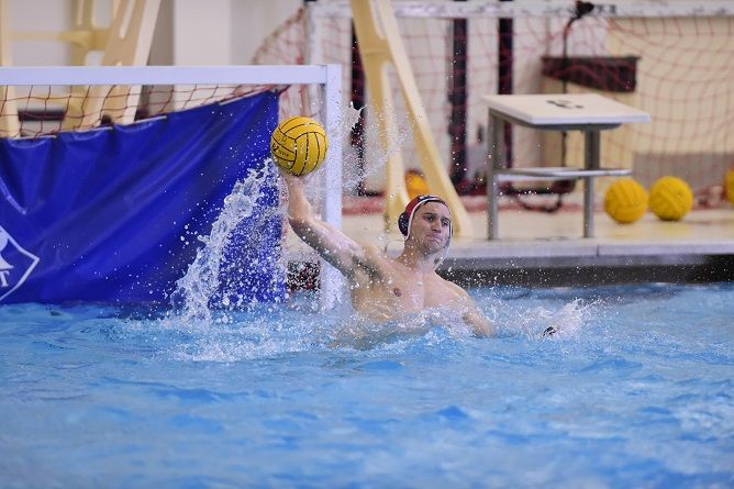 A Penn State Behrend water polo player throws the ball