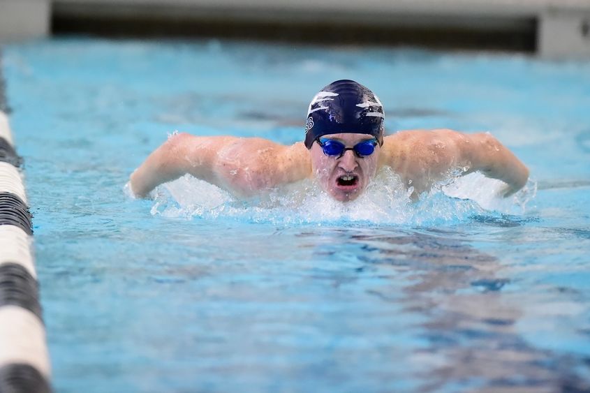 A Penn State Behrend swimmer competes in a race.