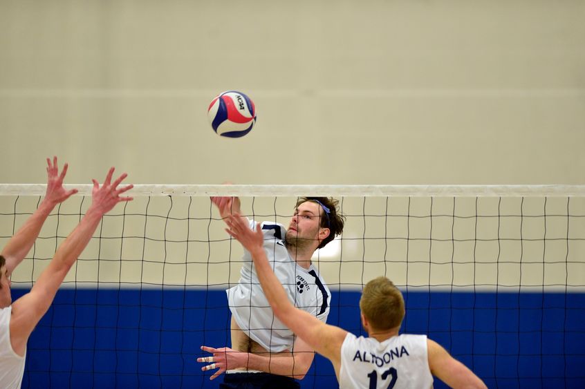 A Penn State Behrend volleyball player spikes the ball