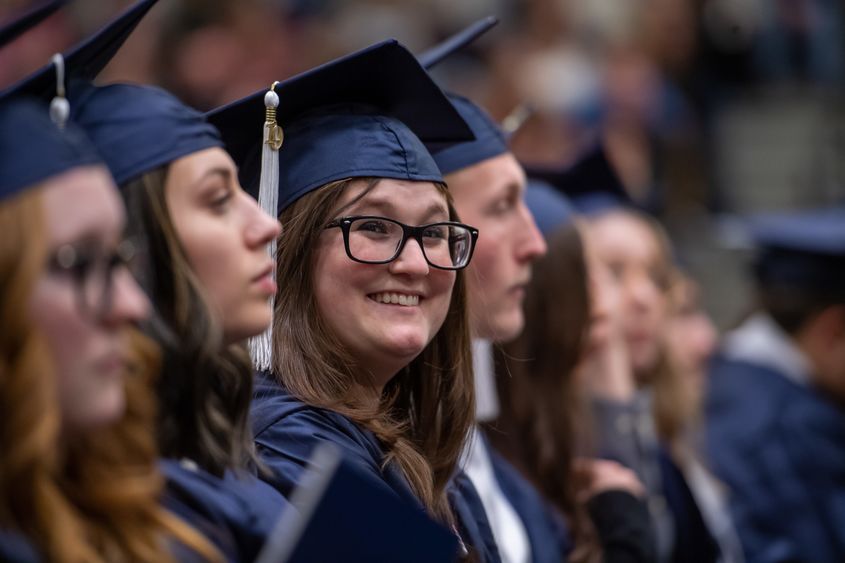 A Penn State Behrend graduate smiles during the college's commencement ceremony.