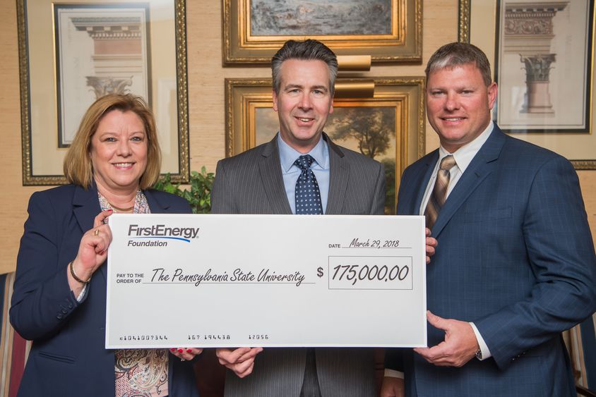 Three people hold a check announcing a donation from the FirstEnergy Foundation.