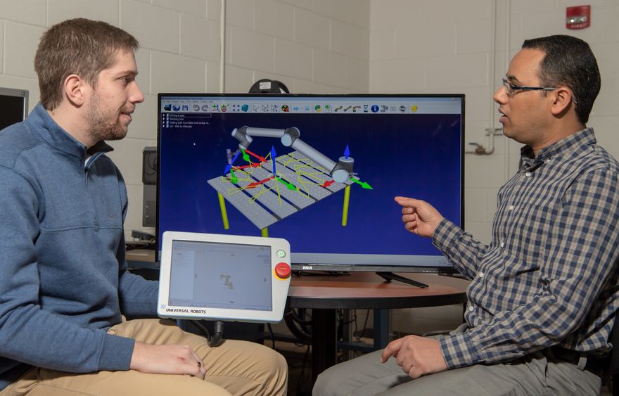 Faisal Aqlan, assistant professor of industrial engineering, uses a manufacturing simulation program while working with a student.