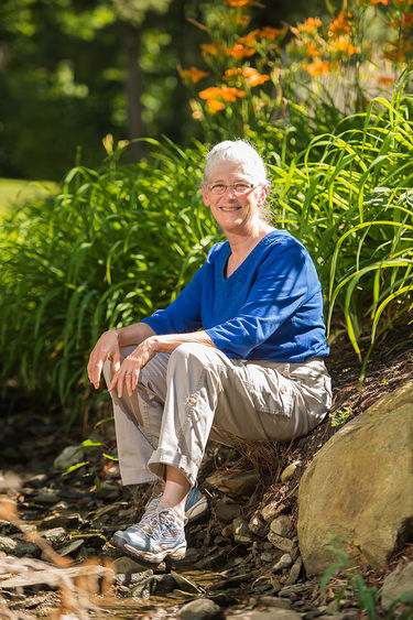 Pam Silver, interim dean for academic affairs at Penn State Behrend, sits next to a stream on campus.