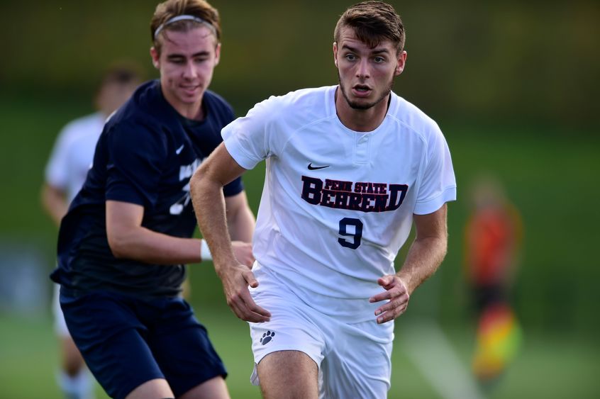 A Penn State Behrend soccer player runs toward the ball.