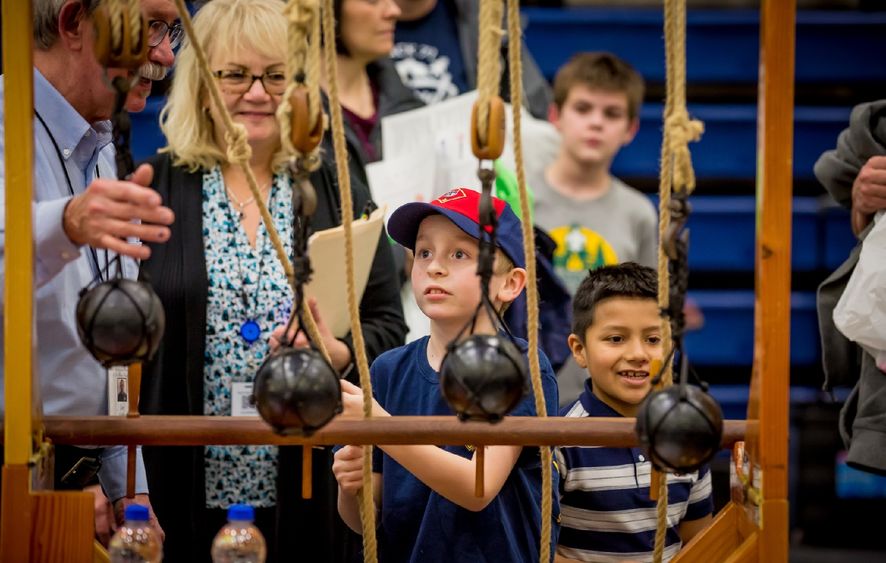 A child tests a pulley system at Penn State Behrend's STEAM fair.
