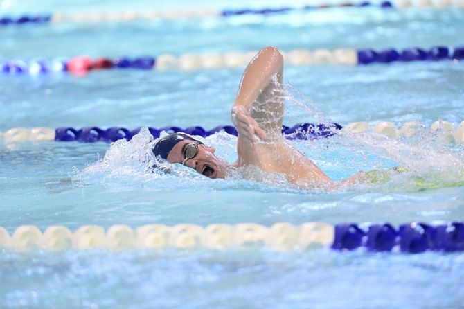 A Penn State Behrend swimmer competes in a freestyle race