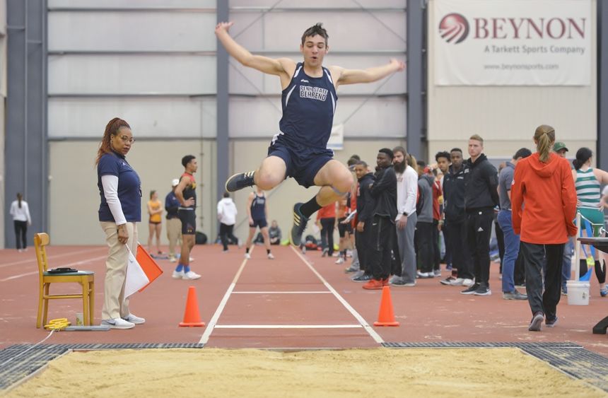 A Penn State Behrend athlete competes in the long jump at an indoor event.