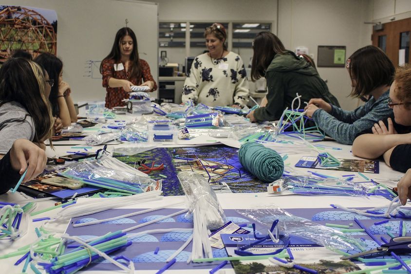 A group of students builds pipe-cleaner structures during the Women in Engineering Day program at Penn State Behrend.