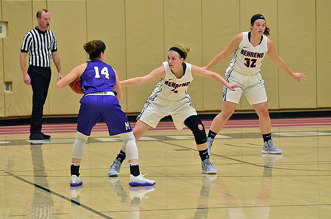 A Penn State Behrend women's basketball player defends the back court as an opposing player approaches.