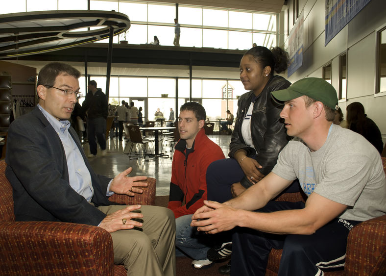 Students talk with an alumnus at the Black School of Business at Penn State Behrend.