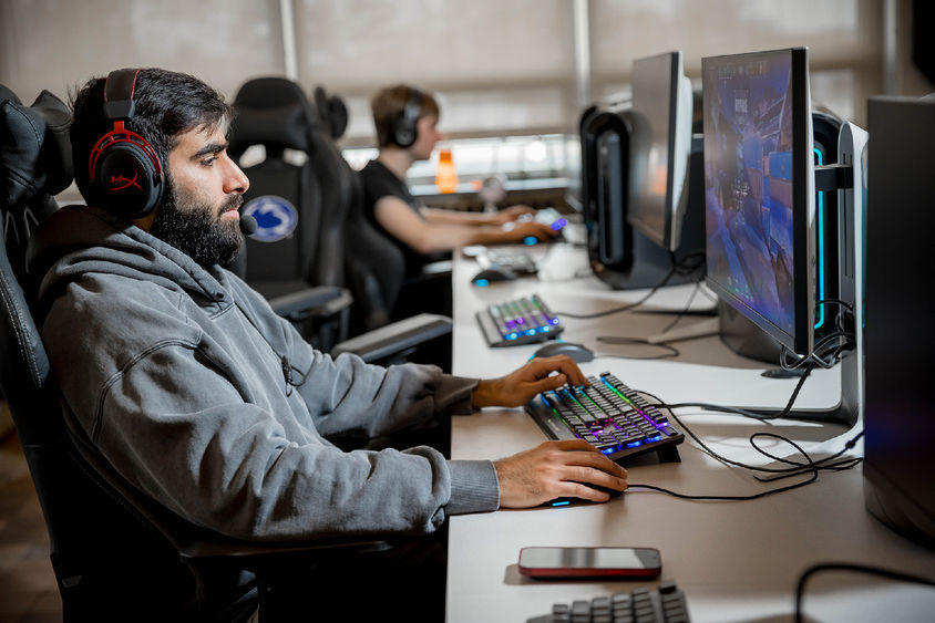 A male student plays a videogame in Penn State Behrend's esports lounge.