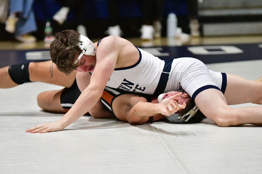 A Penn State Behrend wrestler pins his opponent.