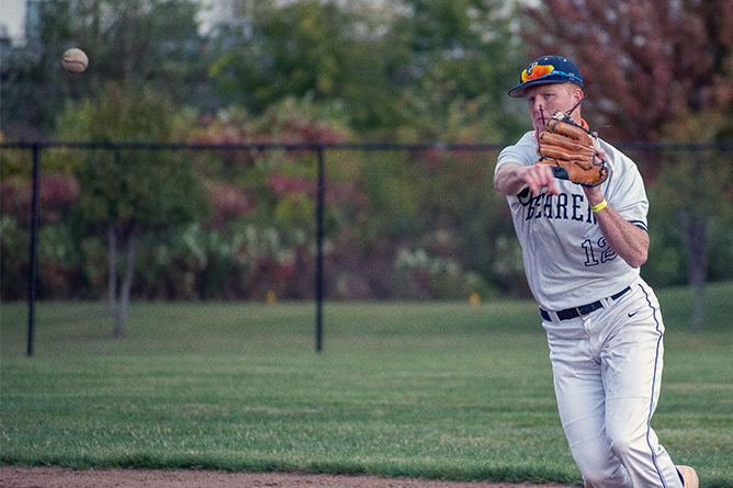 A Penn State Behrend baseball player fields the ball.