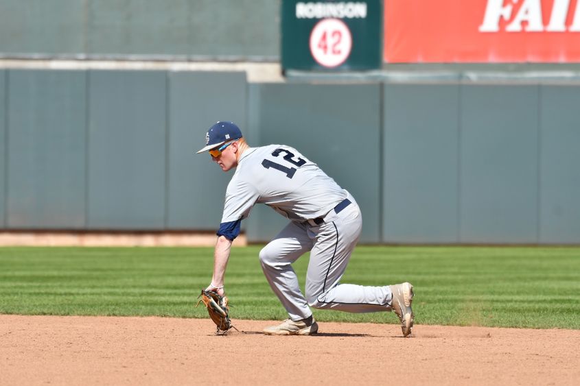 A Penn State Behrend baseball player stops a ground ball in the infield.