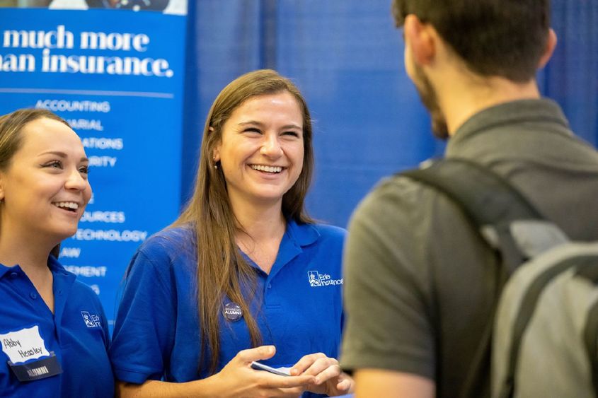 Two female corporate recruiters talk with a student during Penn State Behrend's fall career fair.