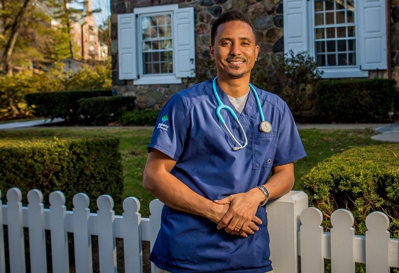 Penn State Behrend graduate Abraham Berhane stands in front of Glenhill Farmhouse.
