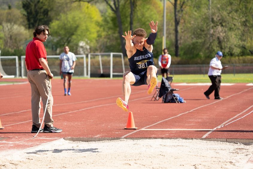 A Penn State Behrend student-athlete competes in the long jump at an outdoor track.