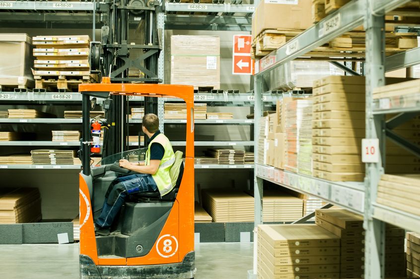 A worker moves product in a warehouse distribution center.