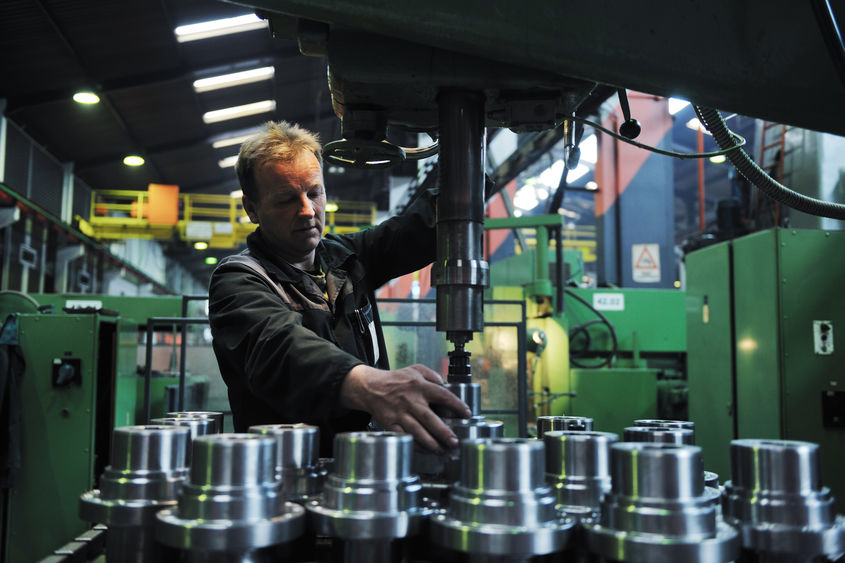 A man operates equipment in an advanced manufacturing environment.