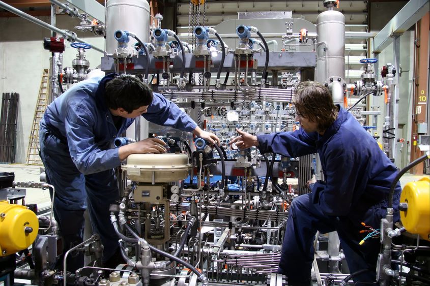 Two employees work in a manufacturing setting.