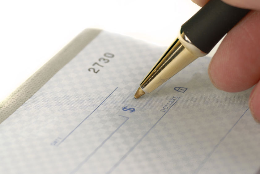 A close-up of a pen writing on a check.