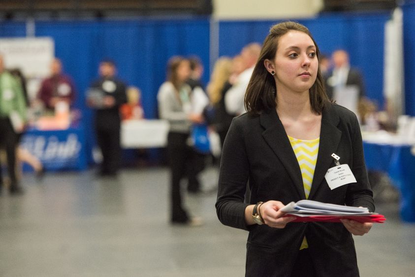 A female student walks down an aisle at a Penn State Behrend Career and Internship Fair