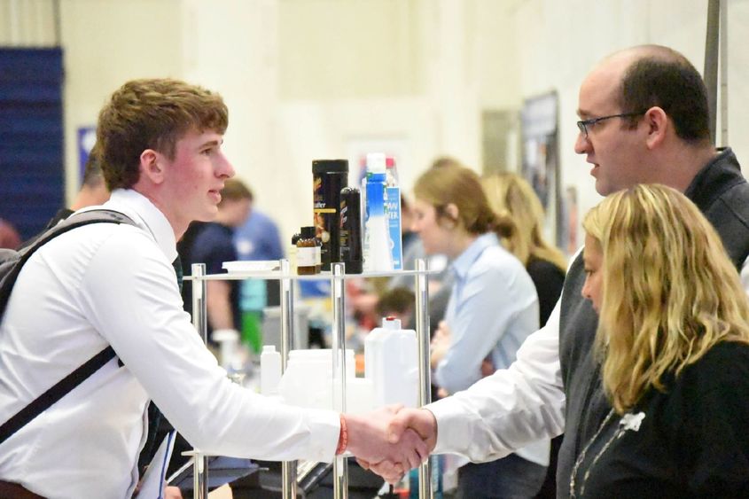 A student shakes hands with a corporate recruiter at Penn State Behrend's Career and Internship Fair.