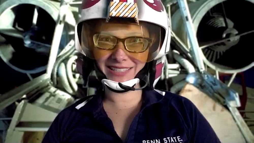 Charlotte de Vries Penn State Behrend professor Charlotte de Vries wears a prop helmet while teaching in front of a spaceship-themed backdrop.